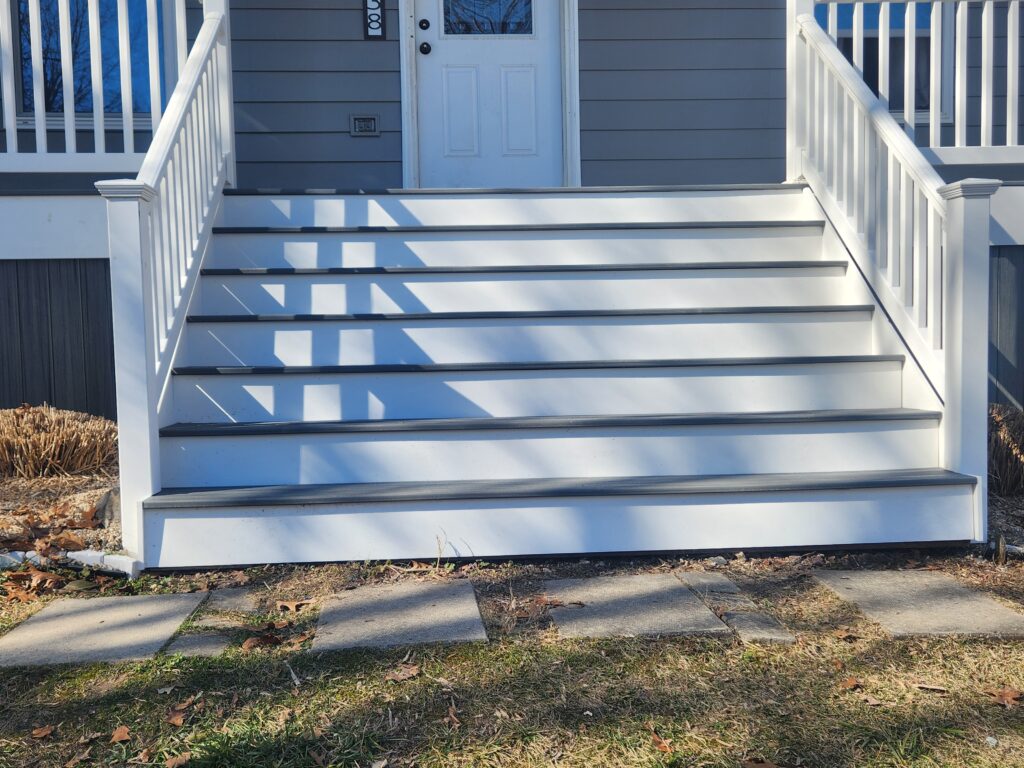 Gray and white deck steps in synthetic wood.