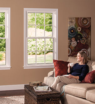 woman looking out living room double hung window