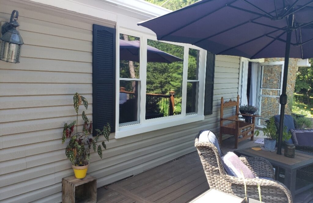 windows on the exterior wall of a home facing a deck