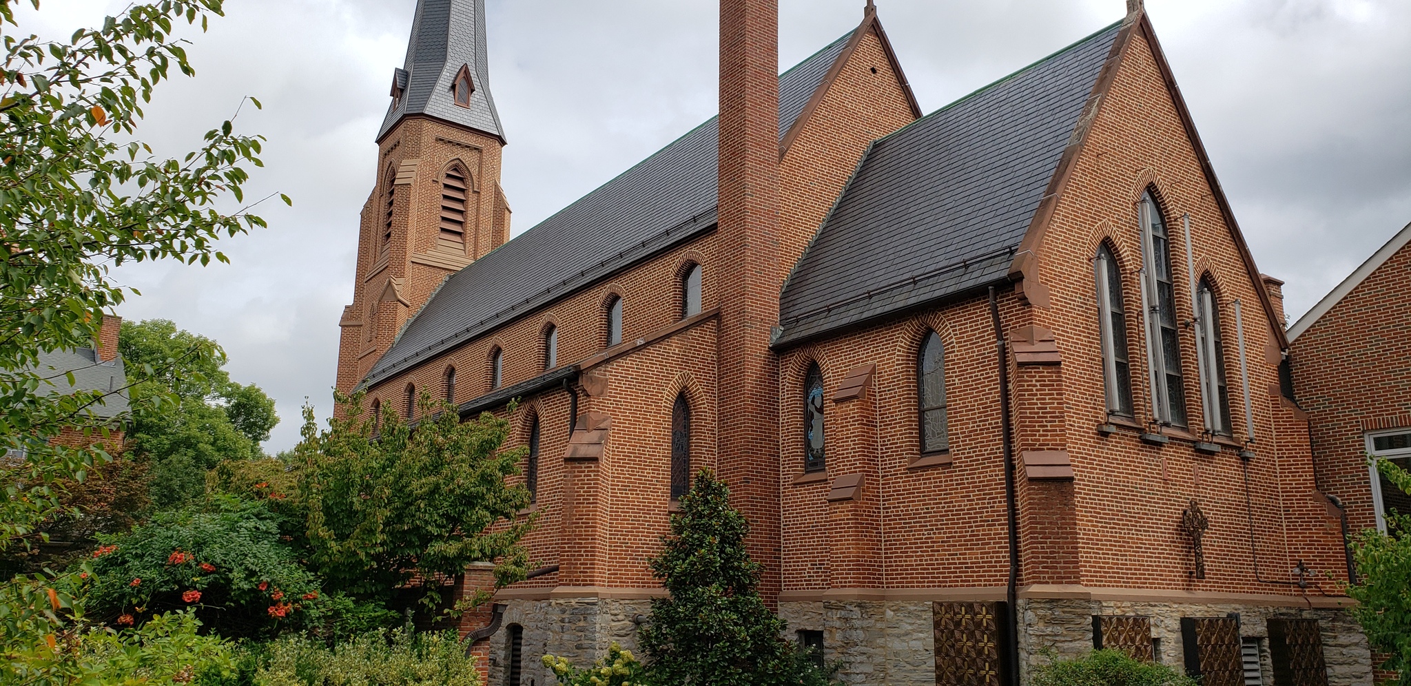 A large brick church with an asphalt shingles roof.
