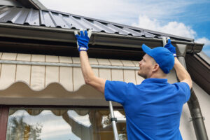 man installing new gutter system on a home